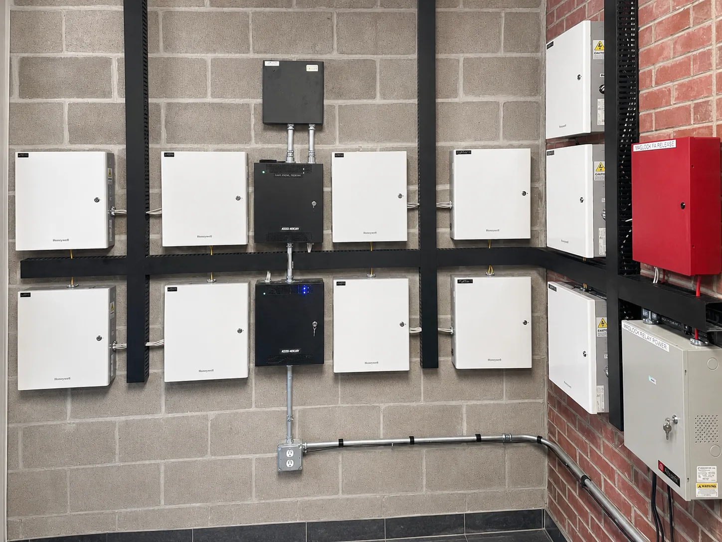 Large wall-mounted access-control system with Honeywell power supplies and control panels at a Bloomington industrial facility
