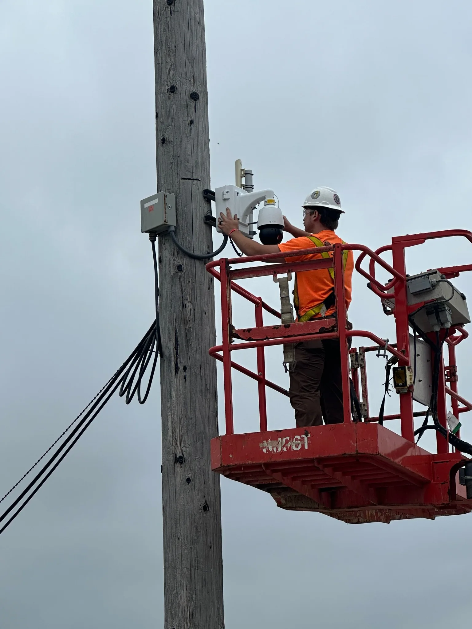 Christenberry Systems technician working on an exterior pole-mounted security camera from a lift at BioUrja Renewables in Peoria Illinois